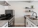 Modern kitchen featuring stainless steel appliances, gray countertop, and wooden style flooring at 2000 Patio Ct # 101, Charlotte, NC 28205