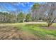 Large backyard is grassy with mature shade trees and an adjacent privacy fence at 2100 Sunderland Pl, Charlotte, NC 28211