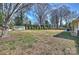 Large, open backyard features an outbuilding, mature trees, and a privacy fence for outdoor enjoyment at 2100 Sunderland Pl, Charlotte, NC 28211