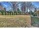 A spacious backyard with a patio area, mature trees, and an adjacent privacy fence at 2100 Sunderland Pl, Charlotte, NC 28211