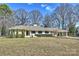 Charming single-story home with well-maintained lawn and mature trees offers picturesque curb appeal at 2100 Sunderland Pl, Charlotte, NC 28211