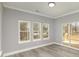 Sunlit room with wood-look flooring and a sliding glass door to the deck with views of a wooded backyard at 2365 Kool Park Ne Rd, Hickory, NC 28601