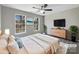 A spacious bedroom with a ceiling fan, two windows, light gray walls, and a comfy rug at 2650 Whisper Ridge Ln, Matthews, NC 28105