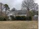Shows the exterior of a one story home with an overgrown yard and peeling paint at 2801 Pennsylvania Ave, Kannapolis, NC 28083