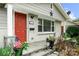 Inviting front porch featuring a vibrant red door, stone accents, and decorative American flags at 3949 Fieldcrest Rd, Charlotte, NC 28217