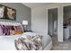 Serene main bedroom with stylish bedding, neutral tones, modern lamp, and access to hallway at 4114 Lattistep Ln, Charlotte, NC 28269