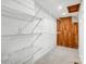 Spacious walk-in closet with built in wire shelving and cedar paneled wall at 4125 Rivendell Ln, Mint Hill, NC 28227