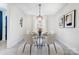 Elegant dining area with a round glass table, modern chairs, decorative lighting, and neutral decor at 4125 Rivendell Ln, Mint Hill, NC 28227