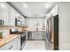 Well-lit kitchen featuring stainless steel appliances, light grey cabinets, and butcher block countertops at 4125 Rivendell Ln, Mint Hill, NC 28227