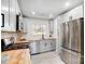 Bright kitchen boasts stainless steel appliances, grey cabinets, and a window offering a backyard view at 4125 Rivendell Ln, Mint Hill, NC 28227