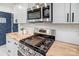 Modern kitchen details with stainless steel stove, microwave, butcher block counters, and sleek white cabinetry at 4125 Rivendell Ln, Mint Hill, NC 28227