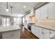 View of the white kitchen with stainless steel appliances and an island overlooking the dining room at 4602 Parkwood School Rd, Monroe, NC 28112