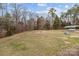 Expansive backyard with mature trees, grassy area, fire pit, and sheltered storage, perfect for outdoors at 47997 Wagoner Rd, Richfield, NC 28137