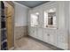 Dual sink vanity in the primary bathroom features white cabinets, stone countertops, and tiled floors at 47997 Wagoner Rd, Richfield, NC 28137