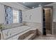 Relax in this bathtub surrounded by decorative tile and natural light from the nearby window at 47997 Wagoner Rd, Richfield, NC 28137