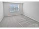 Simple bedroom with gray carpeting and a window with blinds at 6324 Cutwater Cir, Charlotte, NC 28269