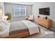 Main bedroom with a light gray bedspread and a wooden dresser at 6324 Cutwater Cir, Charlotte, NC 28269