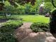 Expansive back yard with lush lawn, mature trees, and a charming stone path at 641 Museum Dr, Charlotte, NC 28207