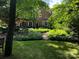 Lush backyard with mature trees and vibrant landscaping surrounding an elegant brick home at 641 Museum Dr, Charlotte, NC 28207