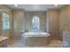 A luxurious soaking tub is centered within a window bay, and is surrounded by custom cabinetry at 641 Museum Dr, Charlotte, NC 28207