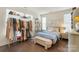 Well-lit bedroom featuring a blue bed, bench, shelving unit, and hardwood floors at 7020 Loso Commons Way, Charlotte, NC 28217
