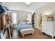 Well-lit bedroom featuring a blue bed, bench, shelving unit, dresser, and hardwood floors at 7020 Loso Commons Way, Charlotte, NC 28217