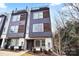 Modern townhome featuring a striking facade with mixed materials and a rooftop deck, enhancing its urban appeal at 7020 Loso Commons Way, Charlotte, NC 28217
