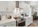 Kitchen features stainless steel appliances, white cabinetry, and a sleek vent hood at 7020 Loso Commons Way, Charlotte, NC 28217