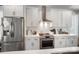Kitchen features stainless steel appliances, white cabinetry, and a sleek vent hood at 7020 Loso Commons Way, Charlotte, NC 28217