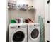 Functional laundry room with washer, dryer, storage shelves, and ironing board at 7020 Loso Commons Way, Charlotte, NC 28217