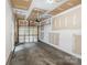 Unfinished one car garage with a partially finished ceiling and concrete floor at 7719 Abigail Glen Dr, Charlotte, NC 28212