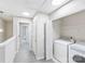 Well-lit hallway with gray carpet leads to laundry area, equipped with washer and dryer at 7719 Abigail Glen Dr, Charlotte, NC 28212