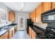 Well-lit kitchen with wood cabinets, black appliances, and dark countertops at 7719 Abigail Glen Dr, Charlotte, NC 28212