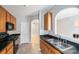 Kitchen view with wood cabinets, black appliances, stainless sink, and view to the living room at 7719 Abigail Glen Dr, Charlotte, NC 28212