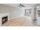 Bright living room featuring a fireplace, wood-look floors, and a ceiling fan at 7719 Abigail Glen Dr, Charlotte, NC 28212
