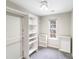 Organized walk-in closet featuring shelving units and a window for natural light at 7719 Abigail Glen Dr, Charlotte, NC 28212