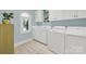Bright laundry room with washer, dryer, cabinets, and window at 10811 Old Tayport Pl, Charlotte, NC 28277
