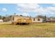 View of the exterior of the home showing the yard, siding, and wooden deck at 1106 Safeway Dr, Gastonia, NC 28056