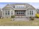 Back of home featuring a stone patio, porch, manicured lawn, and mature landscaping at 11223 Wescott Hill Dr, Huntersville, NC 28078