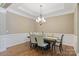 A formal dining room area boasts a decorative chandelier, wainscoting, and hardwood flooring at 11223 Wescott Hill Dr, Huntersville, NC 28078