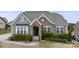 Charming home featuring a stone facade, complemented by lush landscaping and neutral toned siding at 11223 Wescott Hill Dr, Huntersville, NC 28078