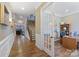 A naturally lit hallway displays hardwood floors, white wainscoting, and open access to a home office at 11223 Wescott Hill Dr, Huntersville, NC 28078