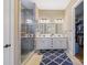 Bright main bathroom with double vanity, walk-in glass shower, tile flooring, and access to walk-in closet at 11223 Wescott Hill Dr, Huntersville, NC 28078