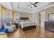 Comfortable main bedroom with hardwood floors, tray ceiling, seating area, and large windows for natural light at 11223 Wescott Hill Dr, Huntersville, NC 28078