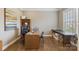 Home office boasts hardwood floors, natural light, and a spacious desk with a rolling leather chair at 11223 Wescott Hill Dr, Huntersville, NC 28078