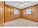 Bright bedroom with wood paneling features a ceiling fan and dual windows for natural light at 115 Winterhaven Rd, Taylorsville, NC 28681