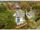 This aerial view shows a home with a pool and outdoor living space in a wooded neighborhood near a lake at 117 Yellow Jacket Cir, Mooresville, NC 28117