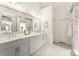 Bright bathroom features dual sinks with white marble counters, gray cabinets, and neutral tile floors at 117 Yellow Jacket Cir, Mooresville, NC 28117