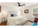 Bedroom with neutral walls, hardwood floors, ceiling fan, and two bright windows at 117 Yellow Jacket Cir, Mooresville, NC 28117