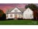 Stunning exterior view of a modern farmhouse with beautiful white siding, gray roof, and a lush green lawn at 117 Yellow Jacket Cir, Mooresville, NC 28117